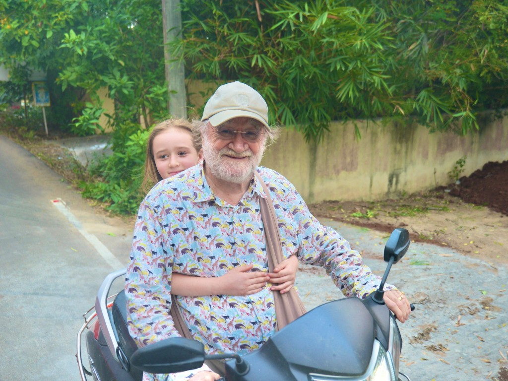 John David on a scooter in India with a young companion